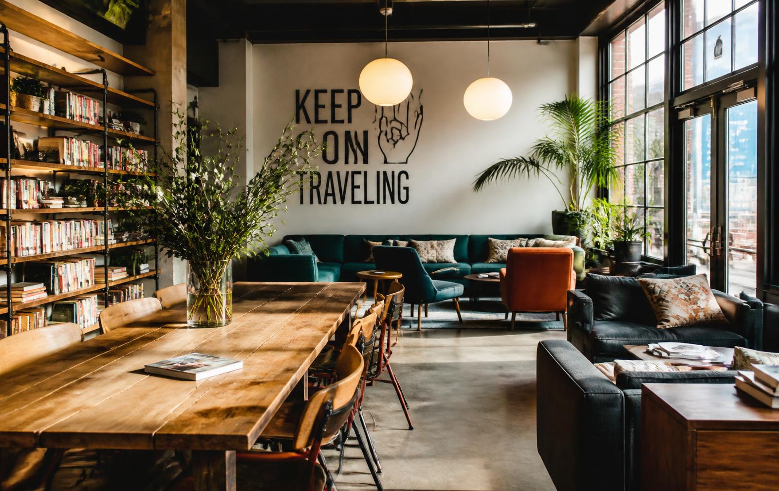 Common room of a modern design hostel with sofas and a long shared table